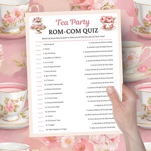 Puede incluir: Una hoja de juego rosa y blanca "Tea Party ROM-COM QUIZ". El cuestionario enumera títulos de películas y pide a los jugadores que los relacionen con los actores correctos. Tazas de té decorativas con diseños florales están en el fondo.