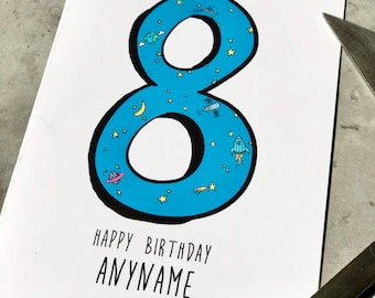 Puede incluir: Una tarjeta blanca con un número ocho azul en ella. El número ocho está lleno de estrellas e ilustraciones con temática espacial. El texto "Happy Birthday ANYNAME" está impreso debajo del número.