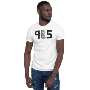 May include: White t-shirt with black text that reads "985" with a graphic of two seashells in the middle of the numbers.