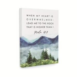 May include: A canvas print with a watercolour landscape depicting mountains and trees, and the text "WHEN MY HEART IS OVERWHELMED; LEAD ME TO THE ROCK THAT IS HIGHER THAN I Psalm 61:2". The artwork has a calming, natural theme.