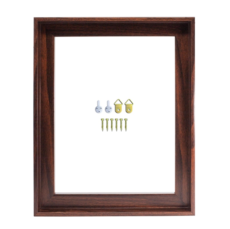 May include: A rectangular, dark brown wooden picture frame with a white interior. Includes hanging hardware: white plastic hooks, gold-colored metal hooks, and small gold screws. Ideal for displaying photos or artwork.
