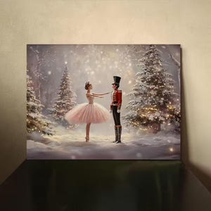 May include: A canvas print depicting a winter scene from the Nutcracker ballet. A ballerina in a pink tutu and a soldier in a red coat stand in a snowy forest with Christmas trees. The artwork has a soft, dreamy quality.