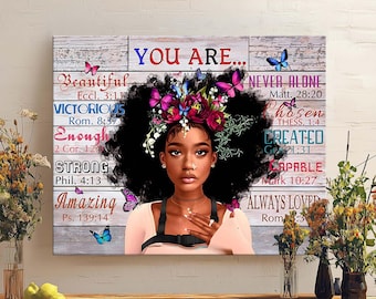 May include: A canvas print featuring a portrait of a woman with a floral headpiece and butterflies. The words "YOU ARE..." are at the top, with inspirational words like "Beautiful," "Victorious," and "Amazing" below. The background has a rustic, wooden plank design.