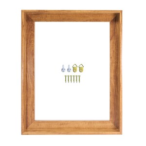 May include: A rectangular wooden picture frame with a light brown finish. Includes picture hanging hardware: three hooks and seven screws. The frame is empty, with a white interior.