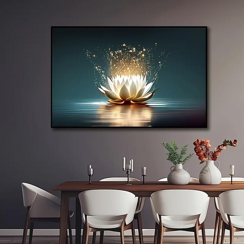 Pu&ograve; includere: Stampa artistica su tela incorniciata con un fiore di loto luminoso. L'opera raffigura un loto bianco e oro con luce scintillante che emana dal centro, riflessa nell'acqua sottostante. Lo sfondo &egrave; di colore verde acqua.