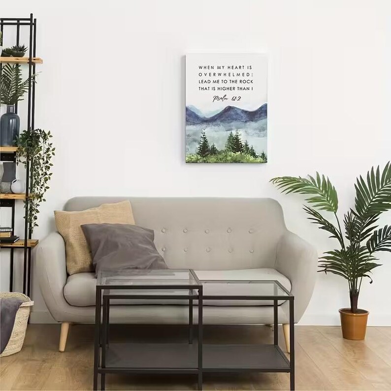 May include: A canvas print with a watercolour landscape of mountains and trees in blue and green hues. The print displays the text "WHEN MY HEART IS OVERWHELMED; LEAD ME TO THE ROCK THAT IS HIGHER THAN I Psalm 612."