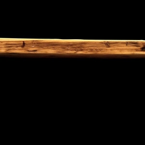 May include: A rustic wooden shelf with a natural wood finish and metal brackets. The shelf is approximately 18 inches long and 6 inches wide.