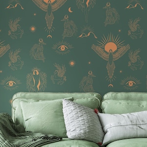 Peut inclure: Un canapé vert avec un plaid et des coussins devant un mur avec un papier peint vert et or représentant un motif répétitif de créatures célestes et mythologiques.