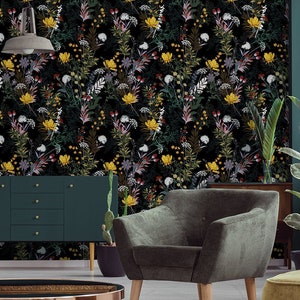 May include: A living room interior with a dark green sofa, a green armchair, and a gold-toned coffee table. The wall is covered in a floral wallpaper with a black background and yellow, white, and pink flowers.