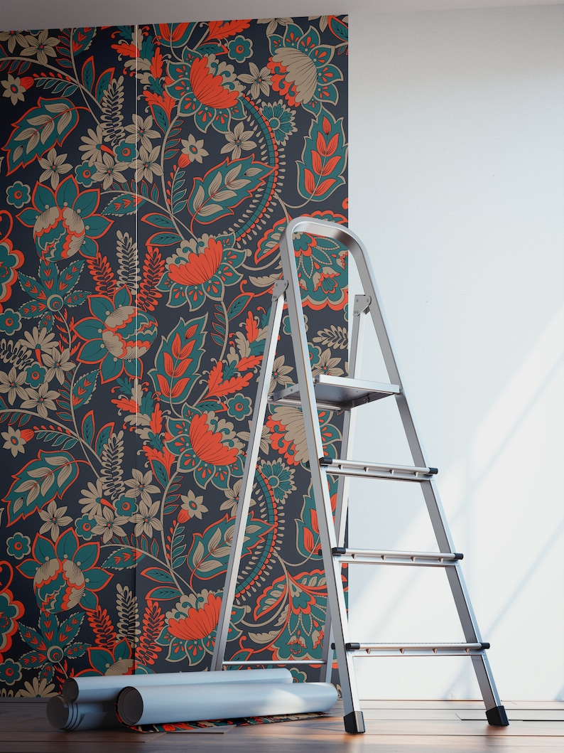 May include: A silver step ladder is positioned in front of a wall covered in teal and orange floral wallpaper. Two rolls of wallpaper are on the floor.