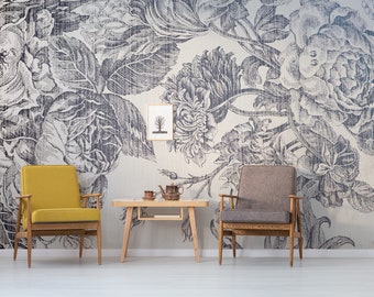 Könnte beinhalten: Zwei Stühle, einer gelb und einer braun, stehen vor einer weißen Wand mit einem schwarz-weißen floralen Tapetenmuster. Ein kleiner Holztisch mit einer Teekanne und Tassen steht zwischen den Stühlen.
