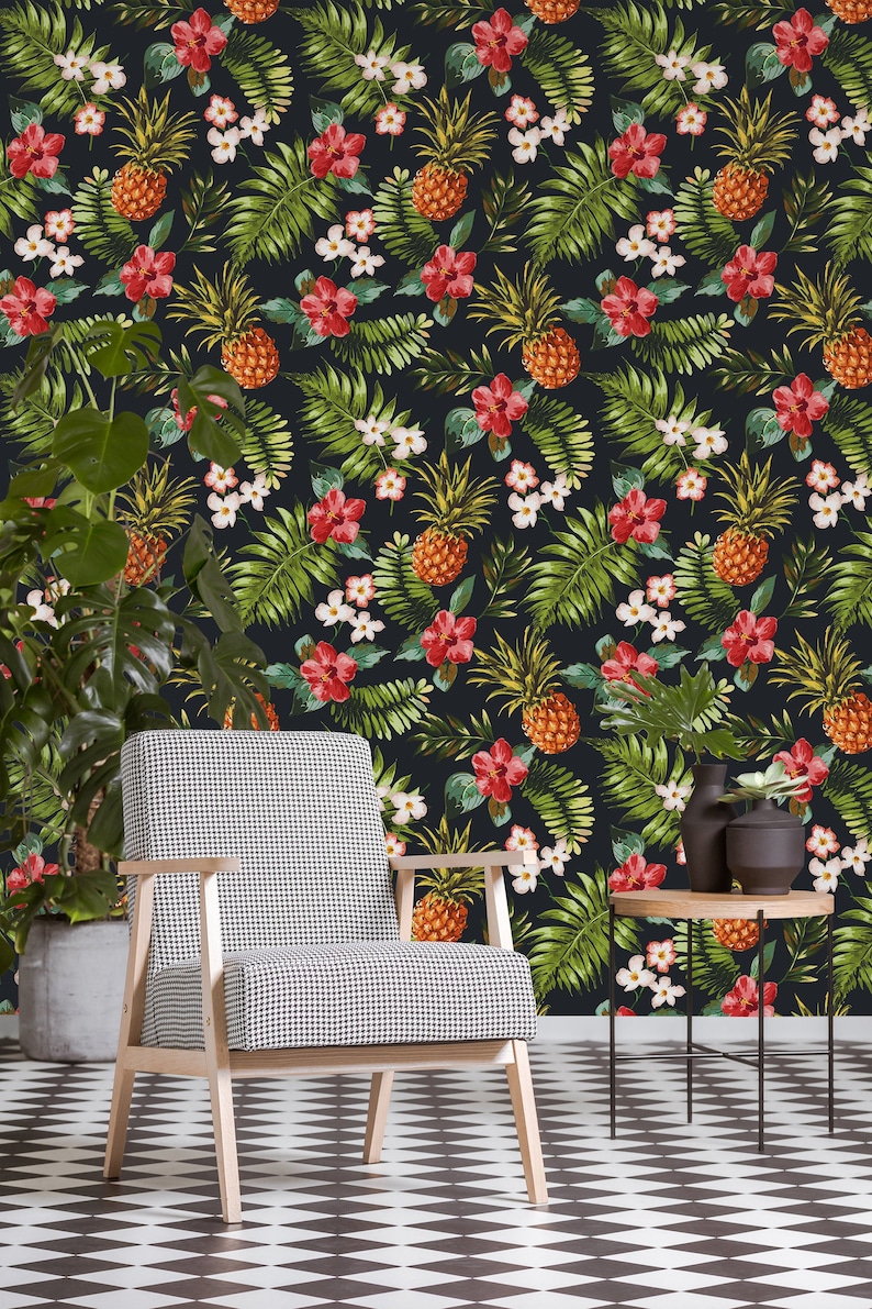 May include: A black and green tropical wallpaper with pineapples, flowers, and leaves. A black and white checkered floor with a wooden chair in the foreground.