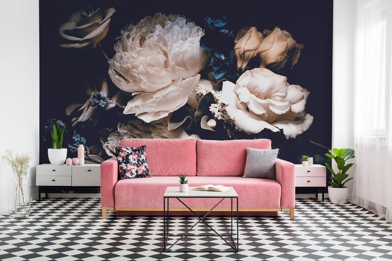 K&ouml;nnte beinhalten: Ein rosa Samtsofa mit zwei Kissen steht vor einer Wandmalerei mit einem dunklen Hintergrund und gro&szlig;en wei&szlig;en und cremefarbenen Rosen.