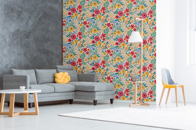 May include: A living room interior design with a gray sectional sofa, a yellow throw pillow, a wooden coffee table, a floor lamp with a white shade, a wooden side table, and a yellow chair. The wall behind the sofa is covered with a floral wallpaper featuring red, yellow, and blue flowers on a cream background.