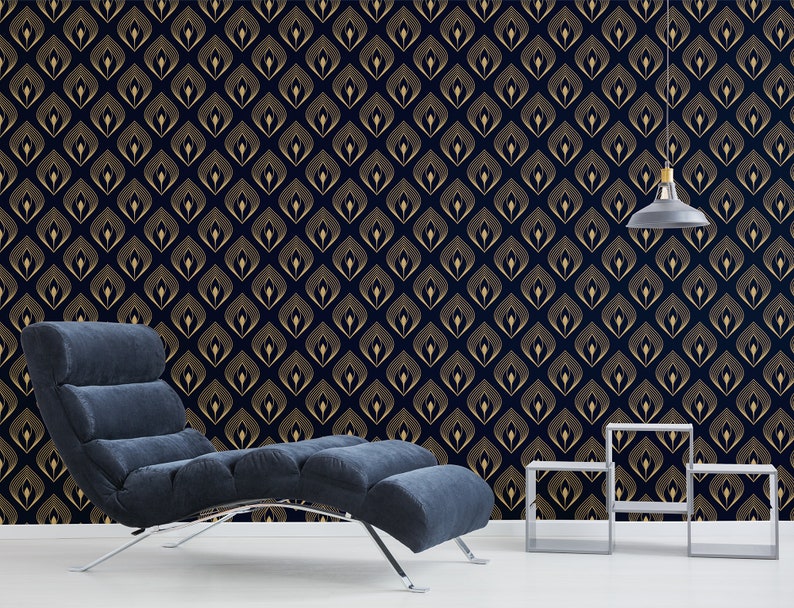 Pode incluir: Uma chaise longue azul escura com uma estrutura prateada fica em frente a uma parede com um papel de parede de padr&atilde;o geom&eacute;trico dourado e preto. Duas pequenas mesas de apoio prateadas ficam em primeiro plano.