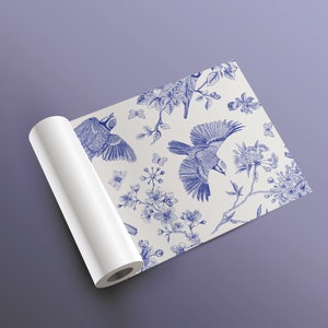 May include: A white background with a blue and white floral pattern featuring birds. The pattern is repeated throughout the design. The background is a white roll of paper.