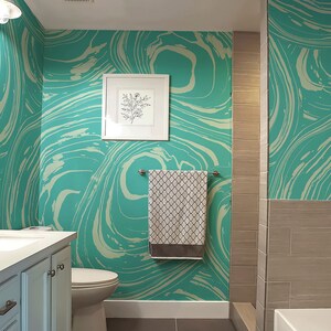 May include: A bathroom with teal and white marbled wallpaper, a white porcelain sink and toilet, a brown tiled shower, and a white towel hanging on a towel rack.