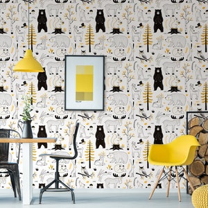 May include: White wallpaper with a repeating pattern of black bears, deer, squirrels, and other woodland creatures. The wallpaper is accented with yellow trees and leaves. The wallpaper is shown in a room with a yellow chair, a table, and a picture frame.