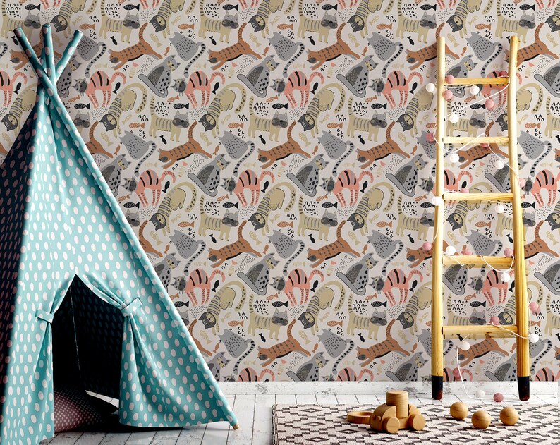 May include: A light blue teepee tent with white polka dots sits in front of a wall with a whimsical wallpaper featuring a repeating pattern of cats, fish, and other animal illustrations in shades of gray, brown, pink, and yellow.