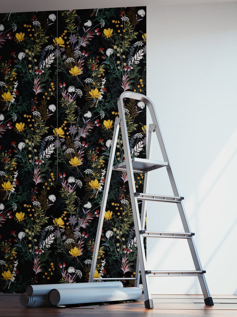 May include: A roll of black and white floral wallpaper with a ladder leaning against a white wall. The wallpaper features a variety of flowers and leaves in a repeating pattern.