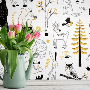 May include: A white background with black and yellow illustrations of woodland animals, including bears, deer, squirrels, owls, and rabbits. A bouquet of pink tulips is in a light blue pitcher in the foreground.
