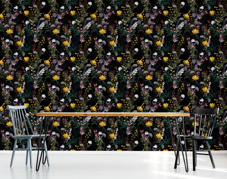 May include: A black and white floral wallpaper with a repeating pattern of yellow, red, and white flowers. The wallpaper is shown in a dining room setting with a wooden table and two black chairs.