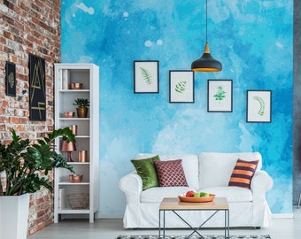 Puede incluir: Salón moderno con sofá blanco, mesa de centro de madera y alfombra con estampado en blanco y negro. La pared azul acuarela está decorada con estampas botánicas enmarcadas y una lámpara colgante negra.
