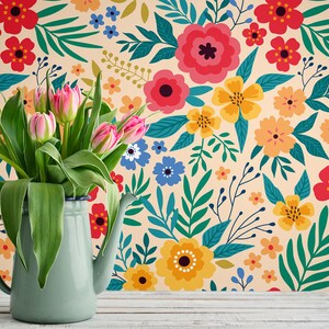 May include: A bouquet of pink tulips in a light blue enamel pitcher against a background of a floral wallpaper with a variety of colorful flowers and leaves.