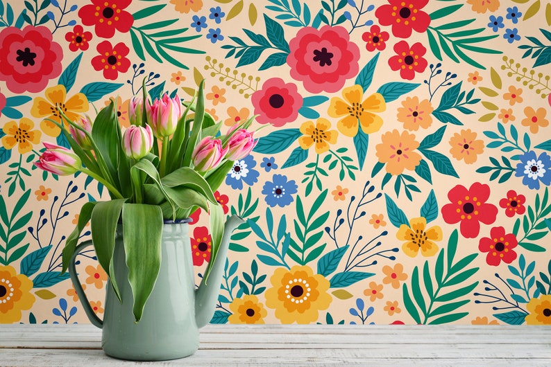 May include: A bouquet of pink tulips in a light blue enamel pitcher against a background of a floral wallpaper with a variety of colorful flowers and leaves.