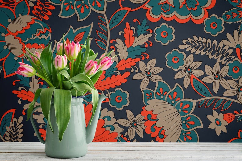 May include: A bouquet of pink tulips in a light blue enamel pitcher against a dark blue background with a floral pattern in shades of teal, orange, and brown.
