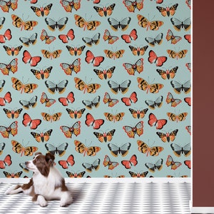 May include: A light blue wallpaper with a repeating pattern of colorful butterflies. The butterflies are in various shades of orange, yellow, red, and brown. The wallpaper is shown in a room with a white floor and a red wall.