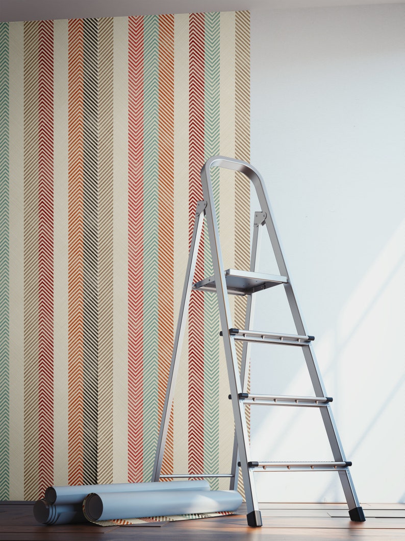 Puede incluir: Un rollo de papel tapiz con un patr&oacute;n de chevron en tonos de rojo, naranja, verde y azul se est&aacute; colocando en una pared con una escalera cerca.