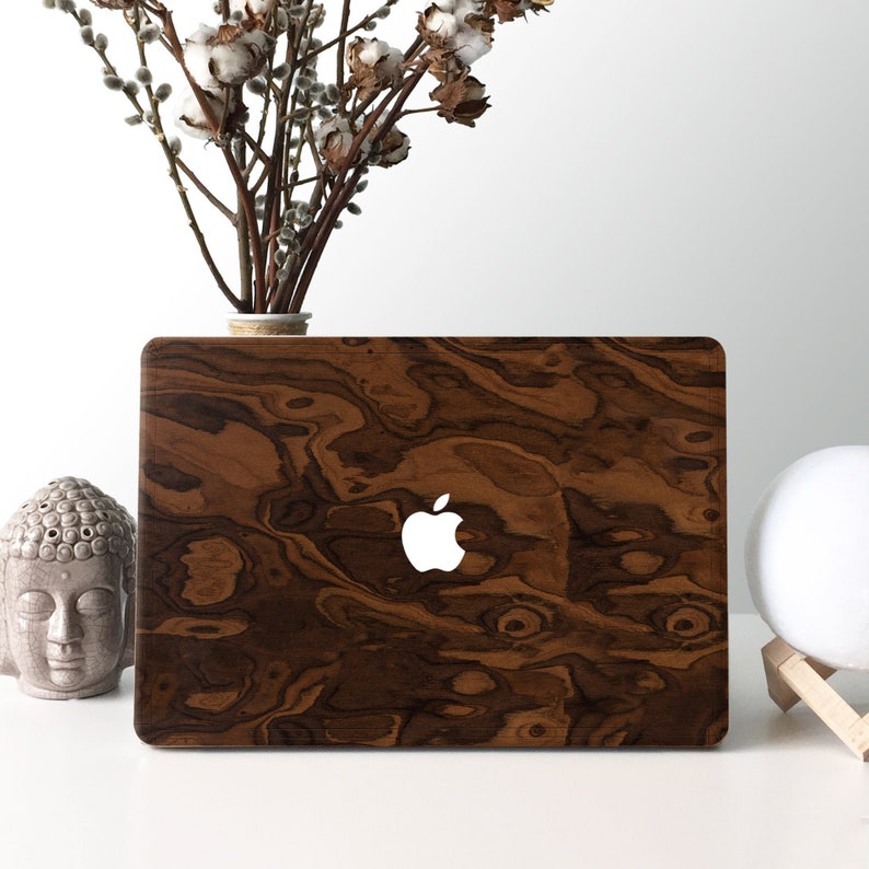 May include: A laptop computer with a wood grain design on the cover. The Apple logo is visible on the cover.