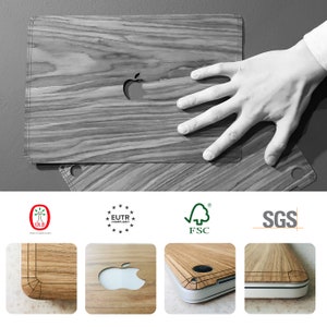 May include: A wood-grain laptop skin with a cutout for the Apple logo. The skin is shown on top of a laptop. The skin is made from real wood and is available in a variety of wood types. The skin is easy to apply and remove, and it leaves no residue behind. The skin is also protected by a clear, scratch-resistant coating. The skin is made from sustainable wood and is certified by the FSC. The skin is also EUTR compliant and SGS tested.