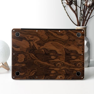 May include: A brown wood-grain laptop skin with a dark brown wood pattern. The skin has a smooth, matte finish and is designed to protect the laptop from scratches and wear.