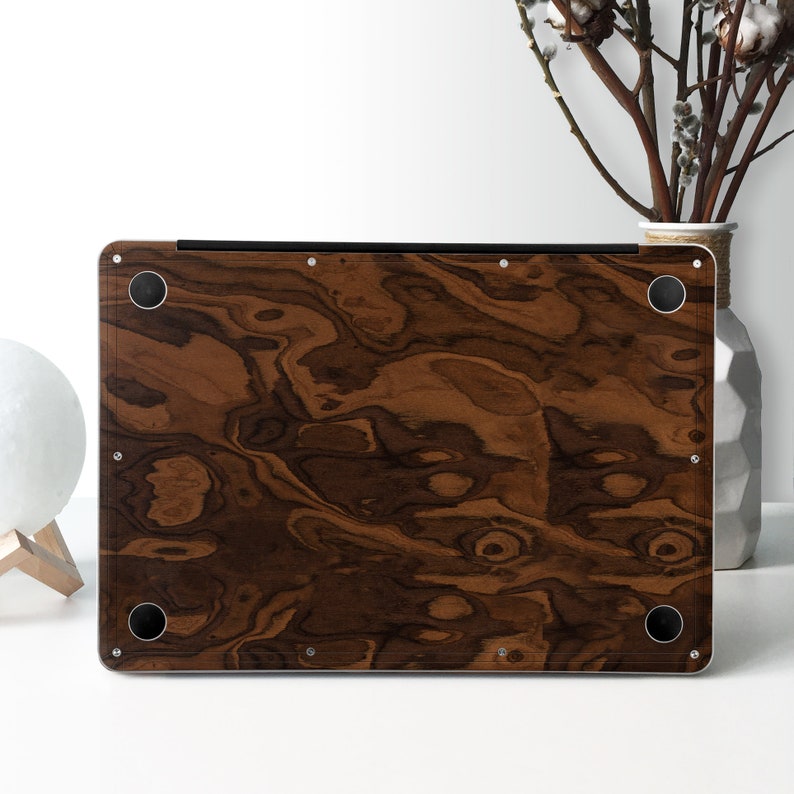 May include: A brown wood-grain laptop skin with a dark brown wood pattern. The skin has a smooth, matte finish and is designed to protect the laptop from scratches and wear.