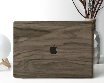 Puede incluir: Un ordenador portátil con un diseño de veta de madera en la tapa. El logotipo de Apple es visible en el centro de la tapa.