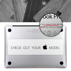 May include: The bottom of a silver MacBook Pro laptop with the text "CHECK OUT YOUR MODEL" and an Apple logo. The model number, A1398, and EMC number, 288, are visible on the sticker.