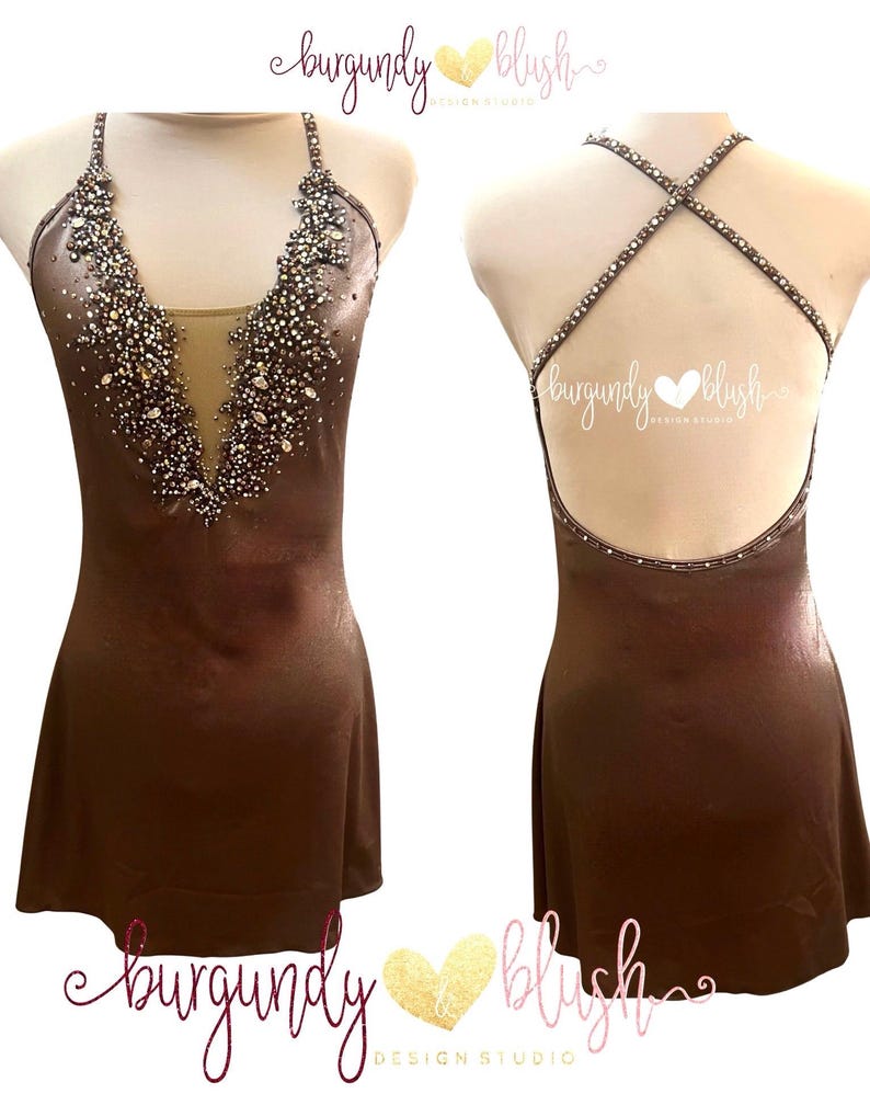 May include: A brown figure skating dress with a halter neckline and open back. The bodice is embellished with sparkling crystals and rhinestones. The dress has a short skirt and is displayed on a mannequin. The text "burgundy blush" is visible.