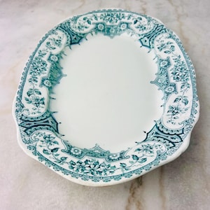 May include: A white oval serving platter with a green floral design around the edge.