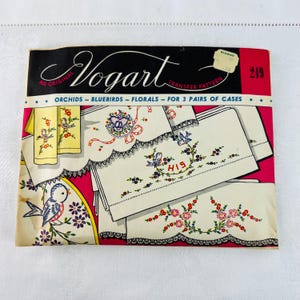 May include: A vintage embroidery transfer pattern for pillowcases featuring bluebirds, orchids, and floral designs. The pattern is titled "Vogart" and includes the text "His" and the number "219".