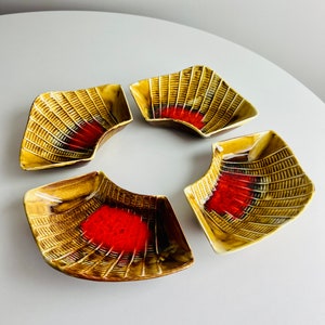 May include: Set of four ceramic dishes with a brown and orange geometric pattern. The dishes are shaped like a crescent moon and have a glossy finish.