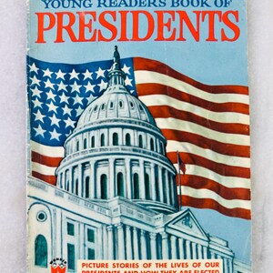 May include: A vintage children's book titled "Young Reader's Book of Presidents". The cover is blue and features the U.S. Capitol building, the American flag, and the title in red. The text "Picture Stories of the Lives of Our Presidents and How They Are Elected" is also visible.