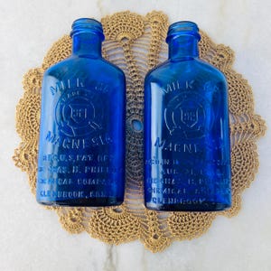 Antiche boccette di vetro blu cobalto del 1906 per latte di magnesia, alte 18 cm; 2 pezzi - vendute singolarmente