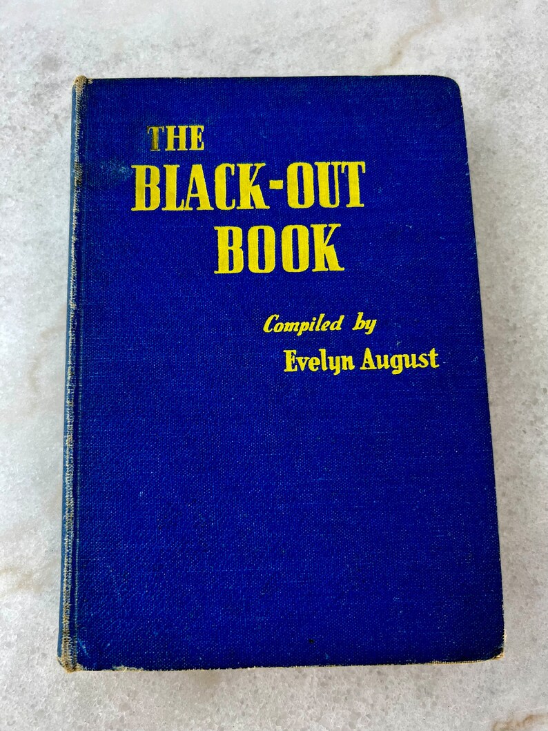 Peut inclure: Un livre bleu avec le titre "THE BLACK-OUT BOOK" en lettres jaunes. Le livre est compil&eacute; par Evelyn August.