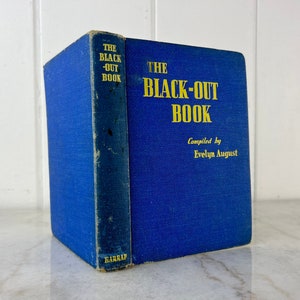 Peut inclure: Un livre reli&eacute; de couleur bleue intitul&eacute; "The Black-Out Book" compil&eacute; par Evelyn August. Le livre est pos&eacute; sur une surface blanche.