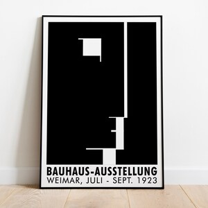 Puede incluir: Póster en blanco y negro con un diseño geométrico y el texto "BAUHAUS-AUSSTELLUNG WEIMAR, JULI - SEPT. 1923".