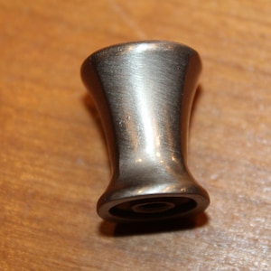 May include: A silver metal cabinet knob with a smooth, rounded design.