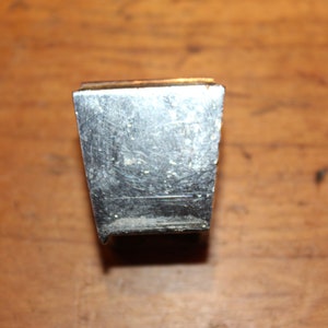 May include: A silver metal rectangular shaped object with a smooth surface.