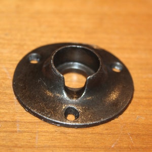 May include: Black metal pipe flange with three screw holes and a round opening.
